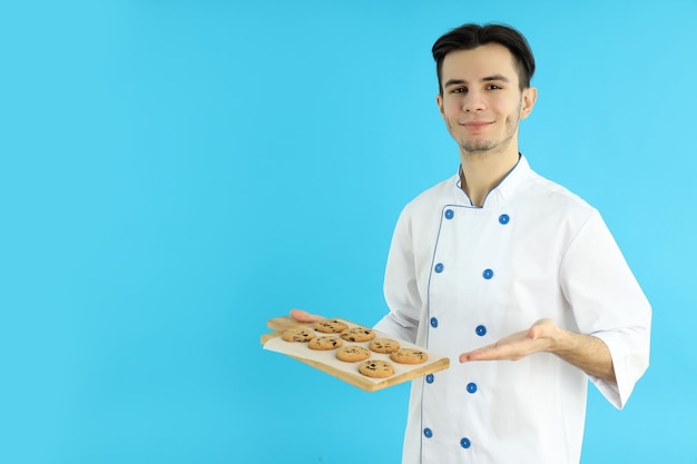 Concept de cuisine jeune chef masculin sur fond bleu