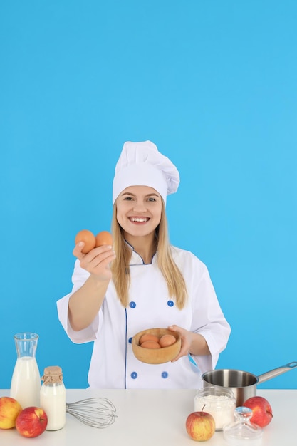 Concept de cuisine avec jeune femme sur fond bleu