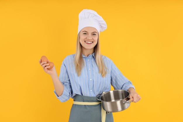 Concept de cuisine avec jeune femme sur fond jaune