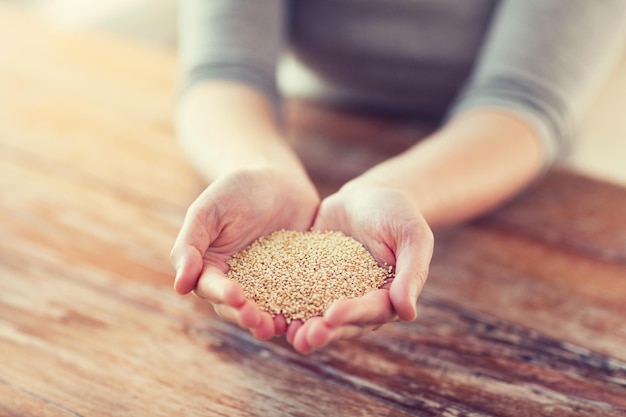 concept de cuisine et de maison - cloes uo de mains féminines en coupe avec du quinoa