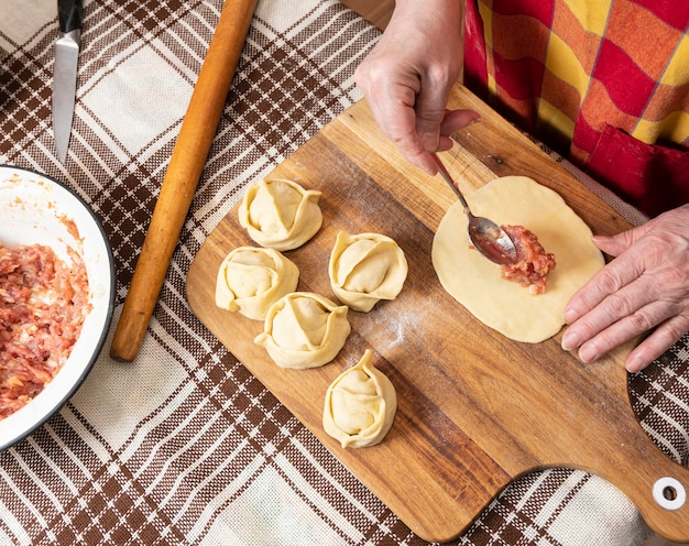 Concept de cuisine maison. Woman making manti avec de la viande de boeuf hachée