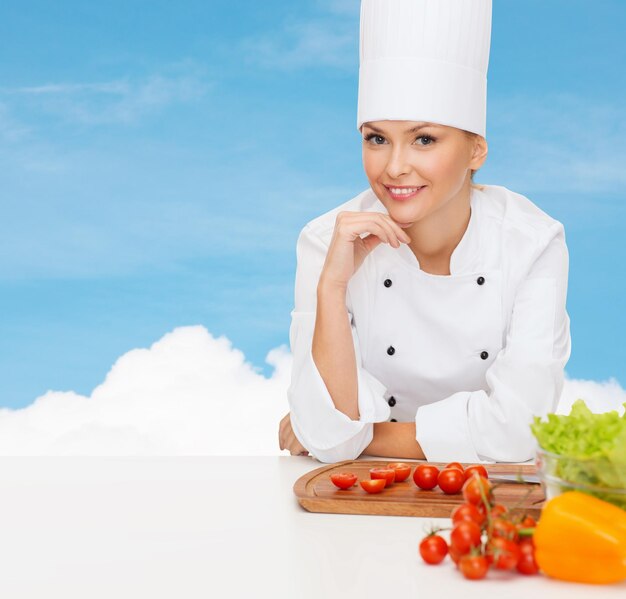 concept de cuisine et de nourriture - femme chef souriante avec des légumes