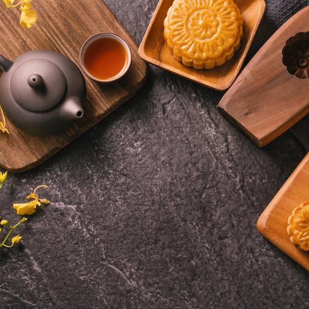 Concept de cuisine traditionnelle du Festival de la mi-automne Beau gâteau de lune sur une table en ardoise noire avec moule à pâtisserie thé fleur vue de dessus espace de copie plat