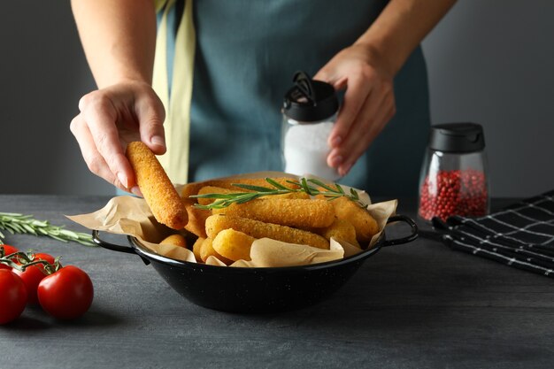 Concept de cuisson des bâtonnets de fromage sur une table sombre