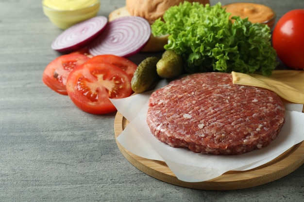 Concept de cuisson burger sur table texturée grise