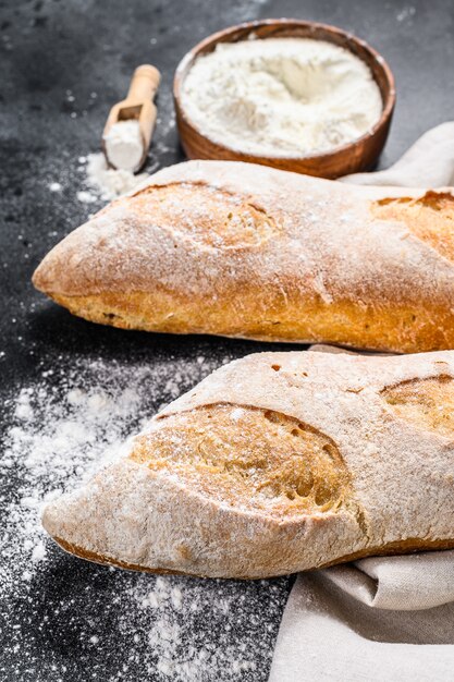 Le concept de la cuisson du pain fait maison. Baguette française. fond noir. vue de dessus