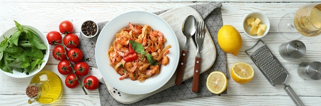 Concept de cuisson des pâtes aux crevettes sur une table en bois blanc