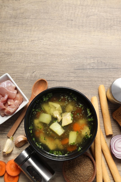 Concept de cuisson de la soupe au poulet ou du bouillon sur fond de bois