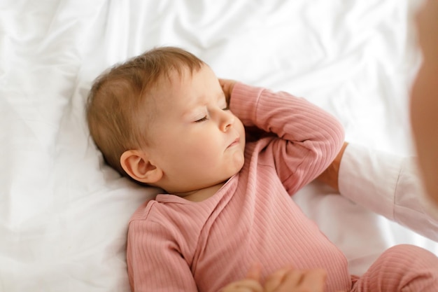 Concept Daysleep Gros plan d'une jolie petite fille dormant dans son lit couché avec les yeux fermés sur des draps blancs