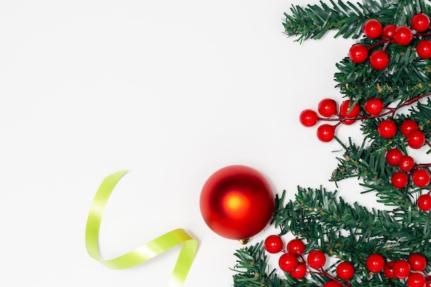 Concept de décoration de Noël Branches de sapin décorant de baies boule rouge et ruban vert
