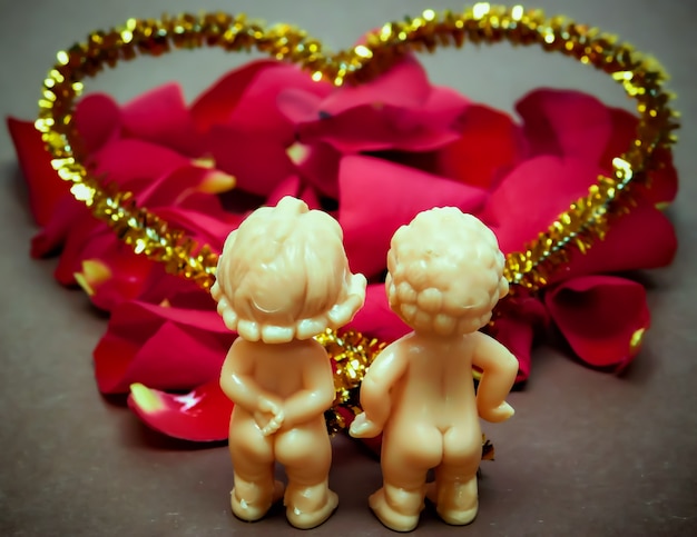 Concept de décoration de la Saint-Valentin-deux amateurs de poupées sur un fond avec des pétales de rose.