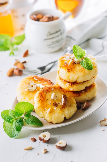 Concept de délicieux aliments de petit déjeuner. Crêpes au fromage cottage, syrniki, beignets au miel