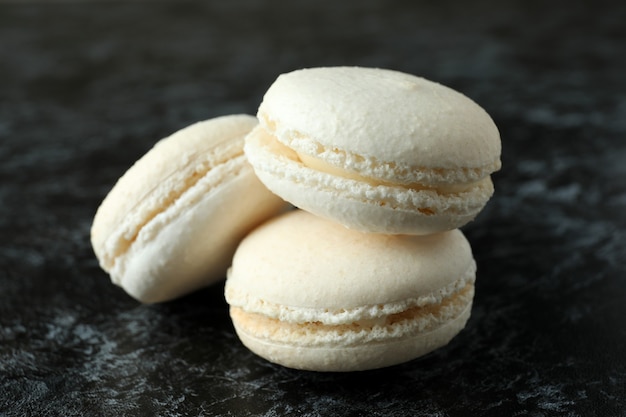 Concept de délicieux dessert avec des macarons sur fond smokey noir