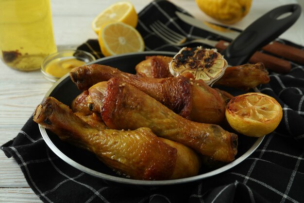 Concept de délicieux repas avec pan de pilons de poulet rôti sur table en bois blanc