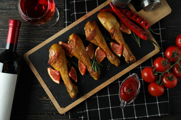 Concept de délicieux repas avec planche de pilons de poulet rôti sur table en bois