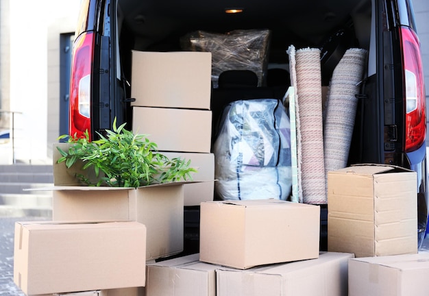 Photo concept de déménagement de maison boîtes de dessin animé dans un coffre de voiture