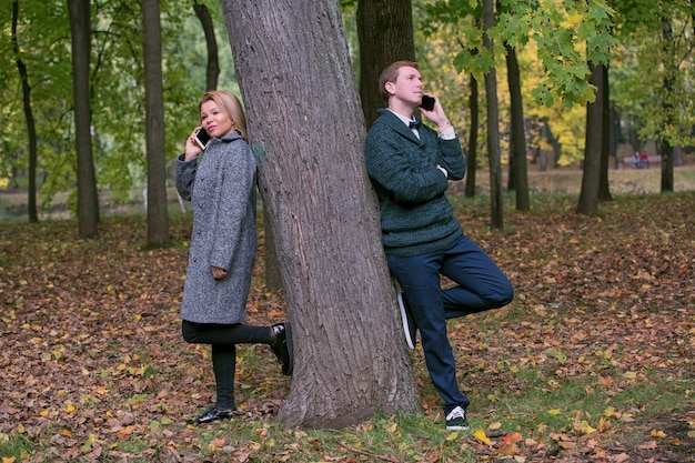 Concept de dépendance au téléphone mobile - couple à l'aide de leur téléphone portable lors d'une date en plein air