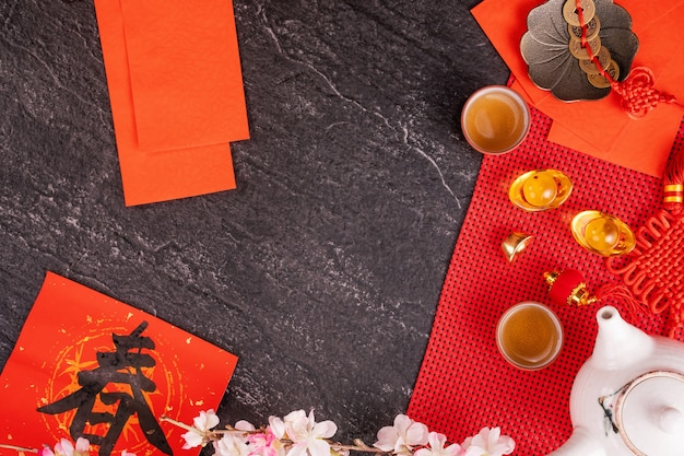 Concept de design du nouvel an lunaire chinois de janvier - Accessoires de fête, enveloppes rouges (ang pow, hong bao), vue de dessus, pose à plat, frais généraux ci-dessus. Le mot «chun» signifie le printemps à venir.
