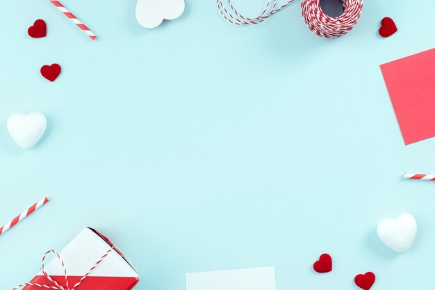 Concept de design de la Saint-Valentin - boîte-cadeau enveloppé rouge, blanc isolé sur fond de couleur bleu clair