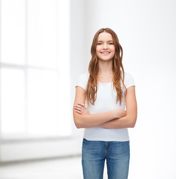 concept de design de t-shirt - adolescent souriant en t-shirt blanc vierge avec les bras croisés