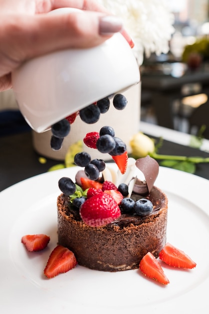 Concept de dessert de confiserie de décoration professionnelle. processus de travail. délicieux gâteau au chocolat.