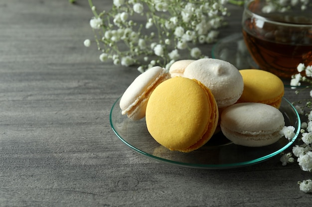 Concept de dessert savoureux avec des macarons sur une table texturée grise