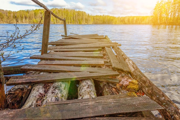 Concept de détente du tourisme de pêche Vue traditionnelle russe finlandaise et scandinave Beau lac forestier ou rivière le jour d'été ensoleillé et vieux quai ou jetée en bois rustique Pont de pêche sur le lac du matin