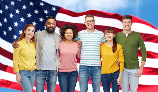 concept de diversité, de race, d'ethnicité et de personnes - groupe international d'hommes et de femmes souriants heureux sur fond de drapeau américain