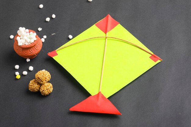 Concept du festival indien makar sankranti, cerf-volant coloré, ficelle et boule de graines de sésame sucré.