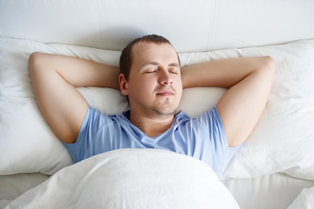 Concept du matin vue de dessus du jeune bel homme dormant dans son lit