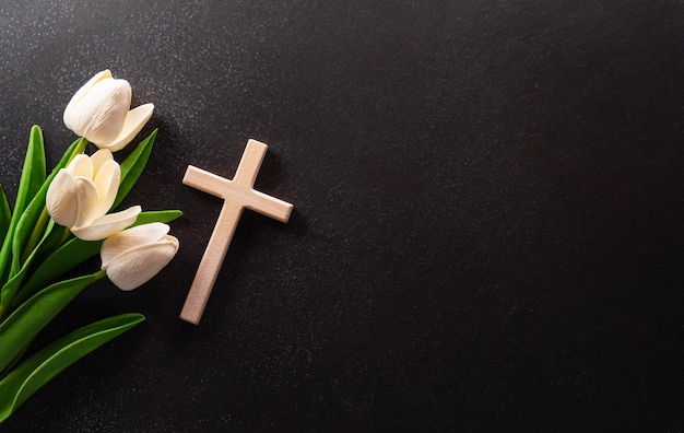 Concept du vendredi saint et de la semaine sainte Une croix religieuse et une fleur sur fond de pierre sombre