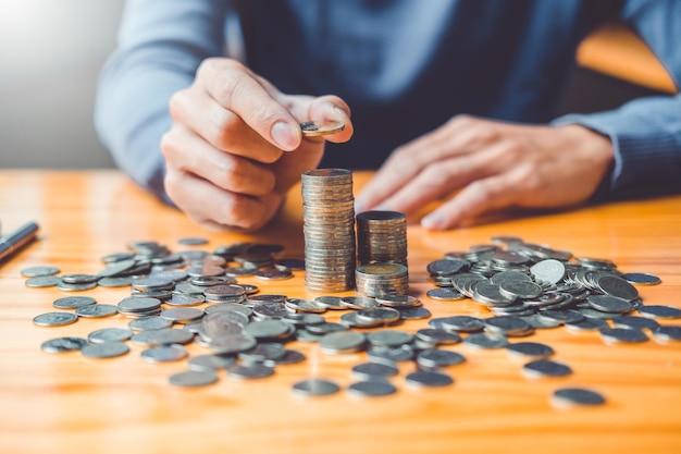 Photo concept d'économie d'argent main de l'homme mettant la rangée et la pièce de monnaie écrire finance concept d'économie d'argent main de l'homme mettant la rangée et la pièce de monnaie écrire la finance