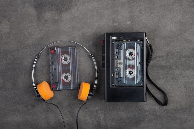 Concept d'écoute de musique Lecteur audio cassette vintage et casque gros plan sur fond de béton gris vue de dessus