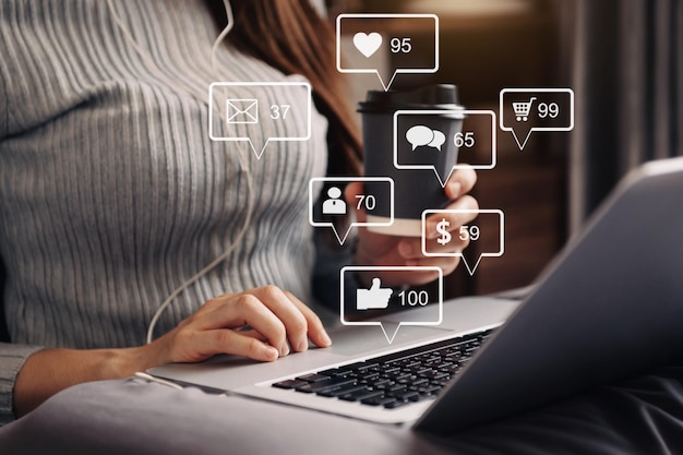 Concept d'écran d'icônes virtuelles de médias sociaux et de marketing gros plan sur une femme d'affaires tapant au clavier