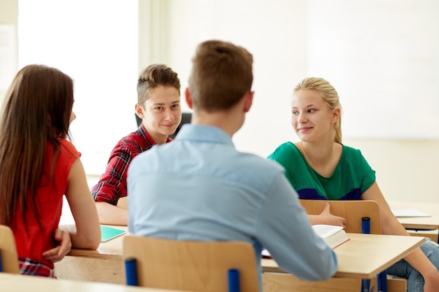 concept d'éducation, d'apprentissage et de personnes - groupe d'étudiants avec des livres et des cahiers à l'école