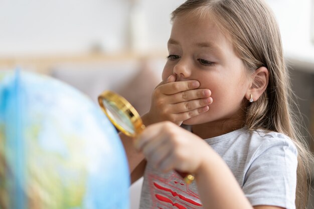 Concept d'éducation et d'école. fille enfant pointant sur globe.