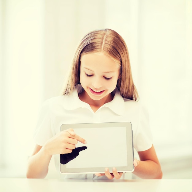 concept d'éducation, d'école, de technologie et d'internet - petite étudiante avec tablette pc à l'école