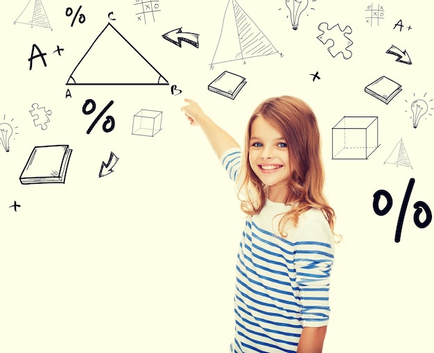 concept d'éducation, d'école et de technologie - jolie petite fille pointant vers le triangle sur l'écran virtuel