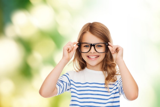 concept d'éducation, d'école et de vision - petite fille mignonne souriante avec des lunettes noires