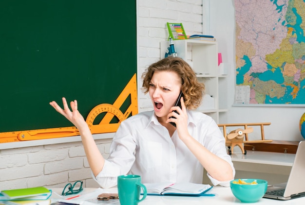 Concept d'éducation enseignant parlant sur smartphone tuteur en colère dans l'étude et l'apprentissage en classe