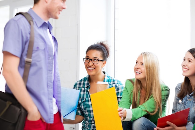 concept d'éducation - étudiants communiquant et riant à l'école