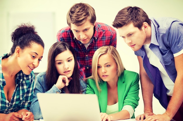 concept d'éducation et d'internet - groupe d'étudiants internationaux regardant un ordinateur portable à l'école