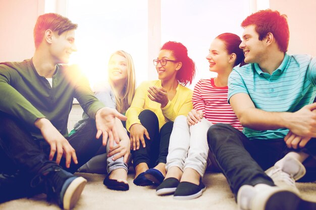 Photo concept d'éducation, de loisirs et de bonheur - cinq adolescents souriants s'amusant à la maison