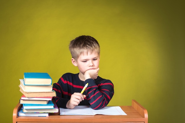 Concept d'éducation Portrait d'enfant avec des difficultés d'apprentissage Garçon fatigué faisant une affectation à domicile