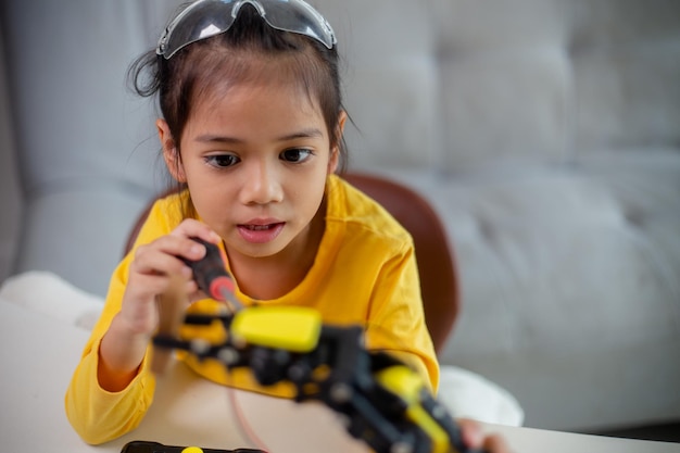 Concept d'éducation STEM Les étudiants asiatiques apprennent à la maison en codant des bras de robot en STEM mathématiques ingénierie science technologie code informatique en robotique pour les concepts des enfants