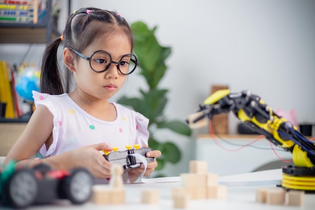 Concept d'éducation STEM Les étudiants asiatiques apprennent à la maison en codant des bras de robot en STEM mathématiques ingénierie science technologie code informatique en robotique pour les concepts des enfants