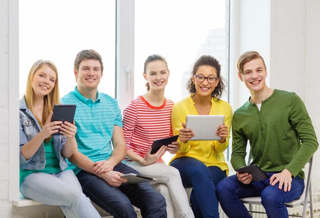concept d'éducation et de technologie - étudiants souriants avec ordinateur tablette à l'école