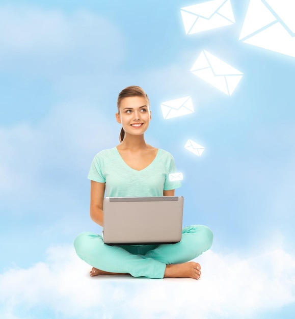 concept d'éducation et de technologie - jeune femme assise sur le nuage avec ordinateur portable