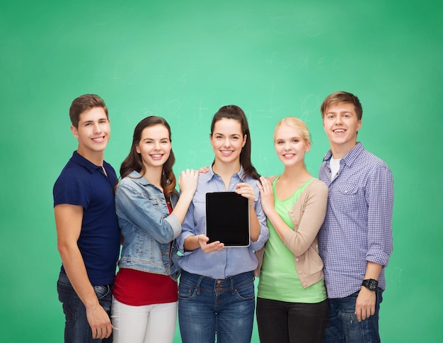 concept d'éducation et de technologie moderne - étudiants souriants montrant un écran d'ordinateur pc tablette vierge