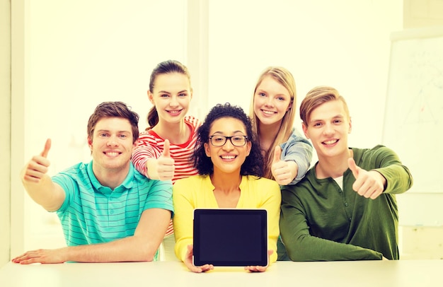 concept d'éducation, de technologie et d'université - cinq étudiants souriants avec un écran vierge d'ordinateur tablette pc à l'école montrant les pouces vers le haut